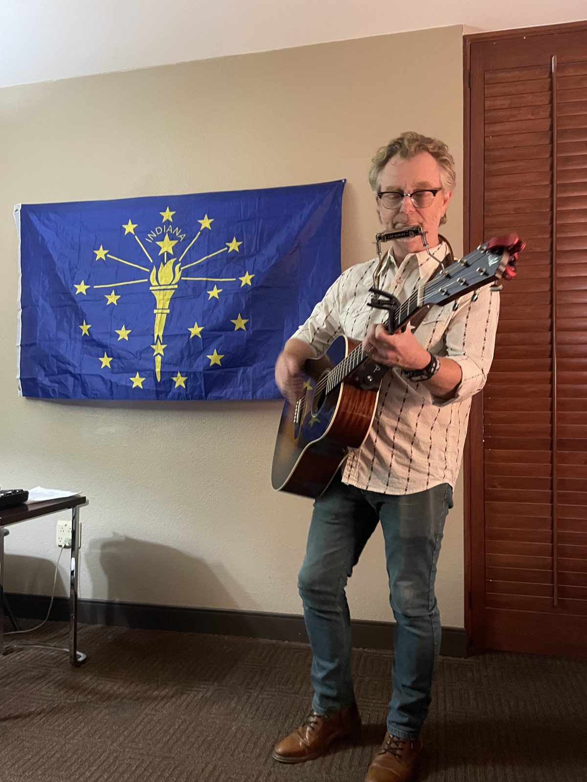 A guitarist performing beside the Indiana flag