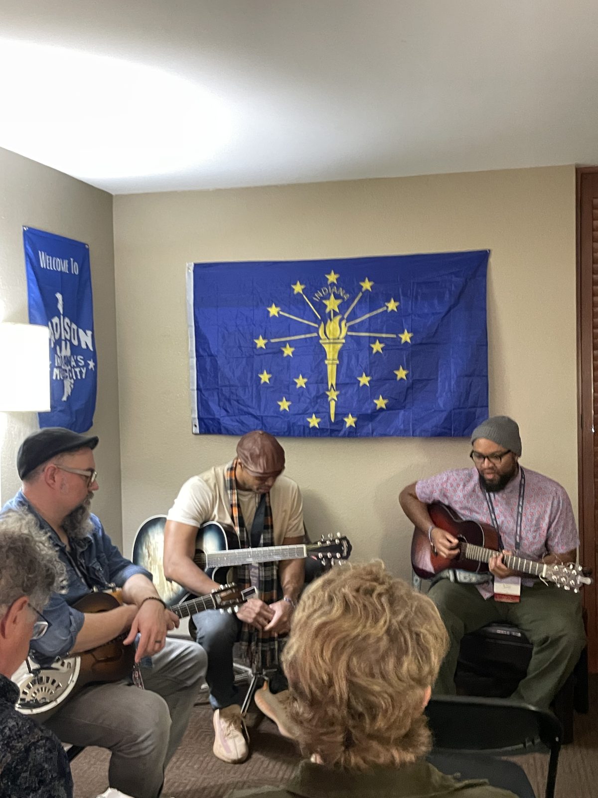 The HooMac room full of listeners with performers under the flag