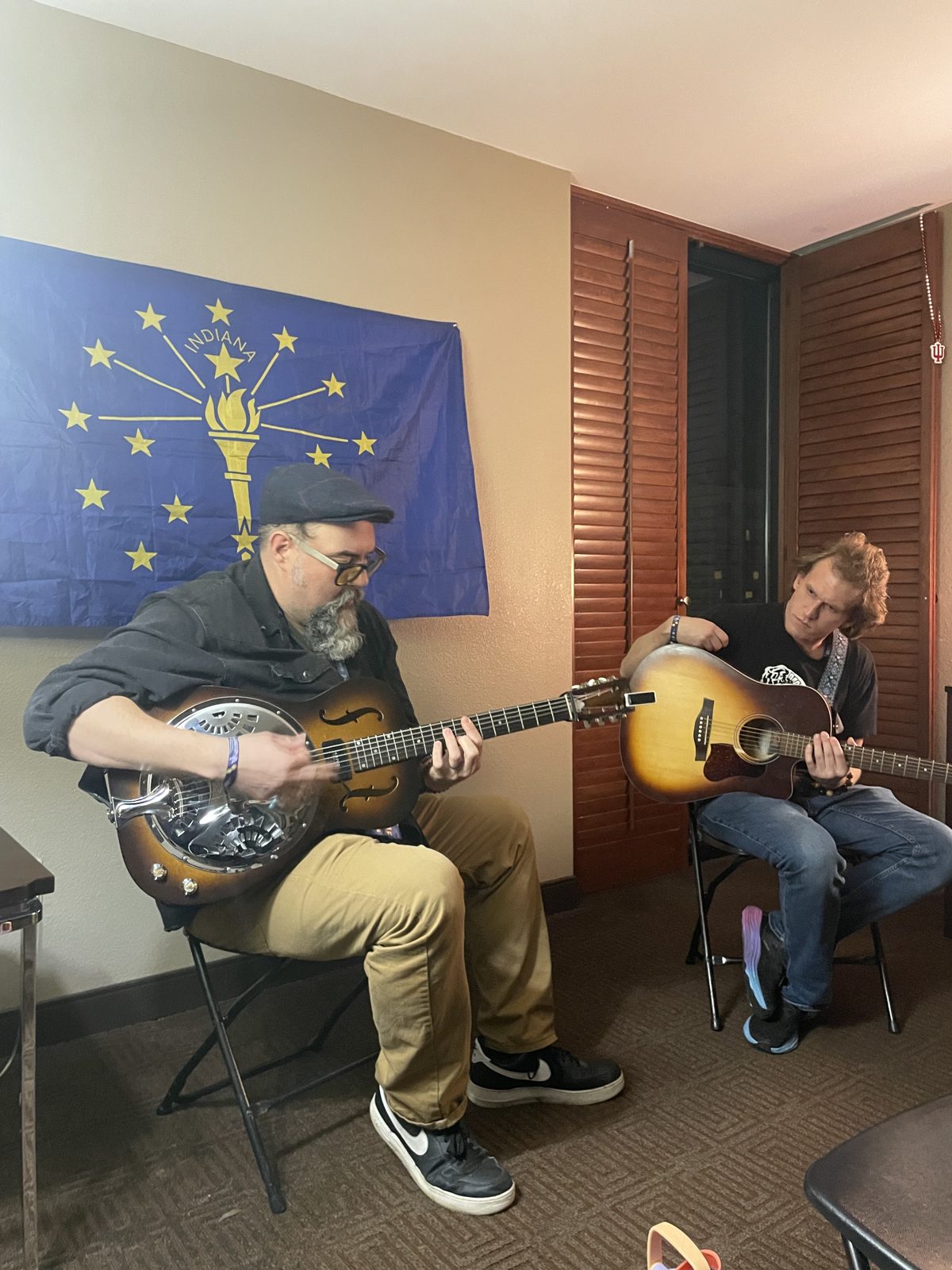 Two seated guitarists performing