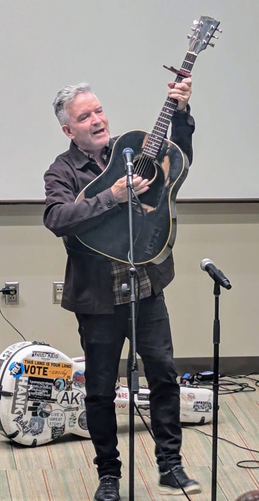 Tim Easton holding his guitar up during the keynote