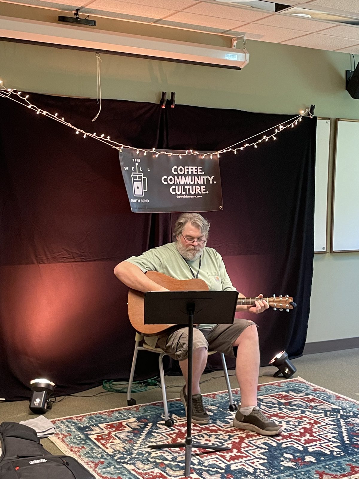 A songwriter performing in The Well Coffeehouse showcase room